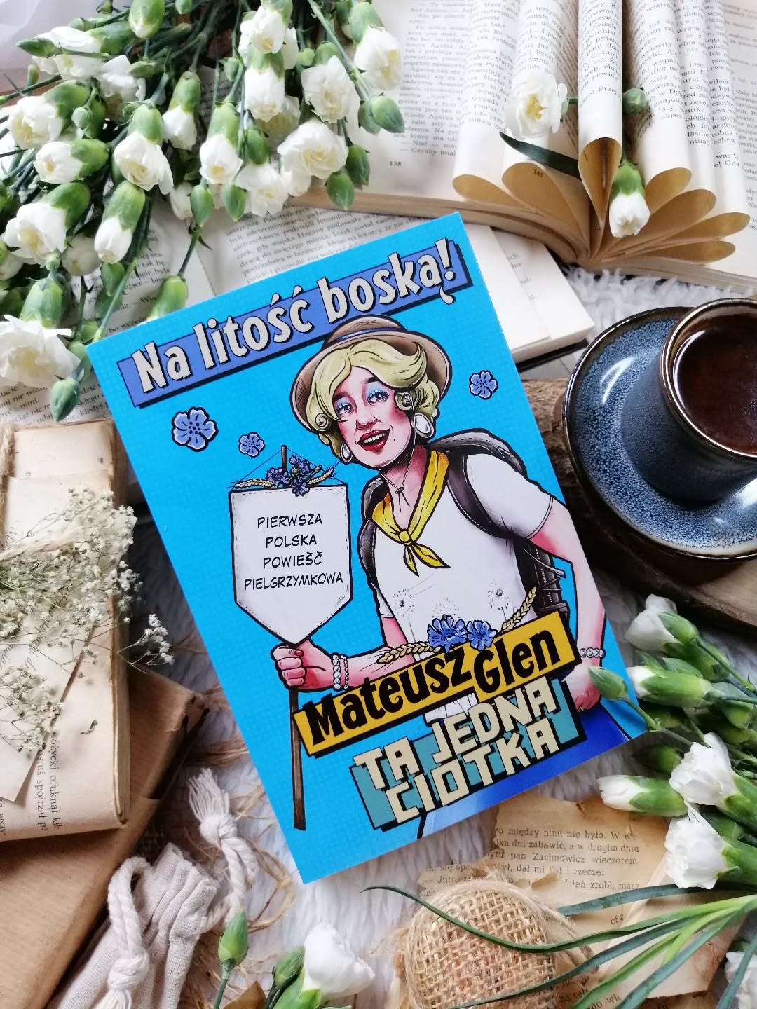 Dzień dobry 🤗  Uśmiałam się! Tak naprawdę, od serca, do łez 🤣  Macie w rodzinie taką ciotkę, która zawsze wie lepiej, daje niechciane rady, jest irytująca i nie przebiera w słowach?  „No tak, toć jak trwoga, to do Ciotki.”  “Na litość boską” Mateusz Glen  Sierpień w Polsce to czas, gdy na drogach i dróżkach pojawiają się pielgrzymi maszerujący w stronę Częstochowy na obchody Wniebowzięcia Najświętszej Maryi Panny. W tym roku do pielgrzymujących dołączają Ciotka, Beata i Kubuś. I już od pierwszej strony wiemy jedno: katastrofy — te małe i te duże — są absolutnie nieuniknione.  Ledwie ruszą, a Beata zostaje zaatakowana przez żmiję. Na szczęście i żmija, i Beata wychodzą z tego spotkania żywe. W gorszej kondycji może być jedynie… Ciotka. Bo w takim razie kto będzie niósł Beatowy plecak? Pogoda kaprysi, ludzie jeszcze bardziej, atmosfera robi się nerwowa. A gdy pojawia się informacja, że trzeba zmienić trasę, bo Jasna Góra została zamknięta z powodu kradzieży obrazu Matki Boskiej, cóż, robi się niewesoło. Ale Ciotka, jak zawsze ma własny plan...  @mateuszglen_official tworzy też przezabawne rolki na Instagramie, w których obnaża wszelkie możliwe przywary starszych pań. Tych pań, które zawsze wiedzą lepiej, bo „za ich czasów…”, kierują się zasadą postaw się, a zastaw się, a do tego mają dyplom z udzielania rad, których nikt nie chce.  Jestem pod ogromnym wrażeniem wyobraźni autora — naprawdę!  A sama Ciotka? To żywioł. Kobieta instytucja. Zadziorna, harda, irytująca do bólu… i absolutnie nie do podrobienia. Nie boi się niczego, wszystkich poucza, krytyki nie przyjmuje, za to rozdaje „zbawienne” rady jak cukierki na odpuście. I oczywiście — jak zawsze — rozwiąże każdą sprawę, choć czasem aż strach patrzeć w jaki sposób.  Absurdy gonią absurdy, stereotypy z przymrużeniem oka, a nasza codzienność staje się błyskotliwą parodią. Dialogi błyszczą, riposty trafiają w punkt, styl jest lekki i swobodny. Mamy też intrygującą zagadkę, szczyptę kryminału i masę komediowych sytuacji.  Ciotka po prostu wymiata!  Bardzo polecam 😊  [współpraca barterowa - @znakjednymslowem]  #nalitośćboską #komedia #czyta #jaczytam #książki #ksiazkitozycie #polecam #znakjednymsłowem