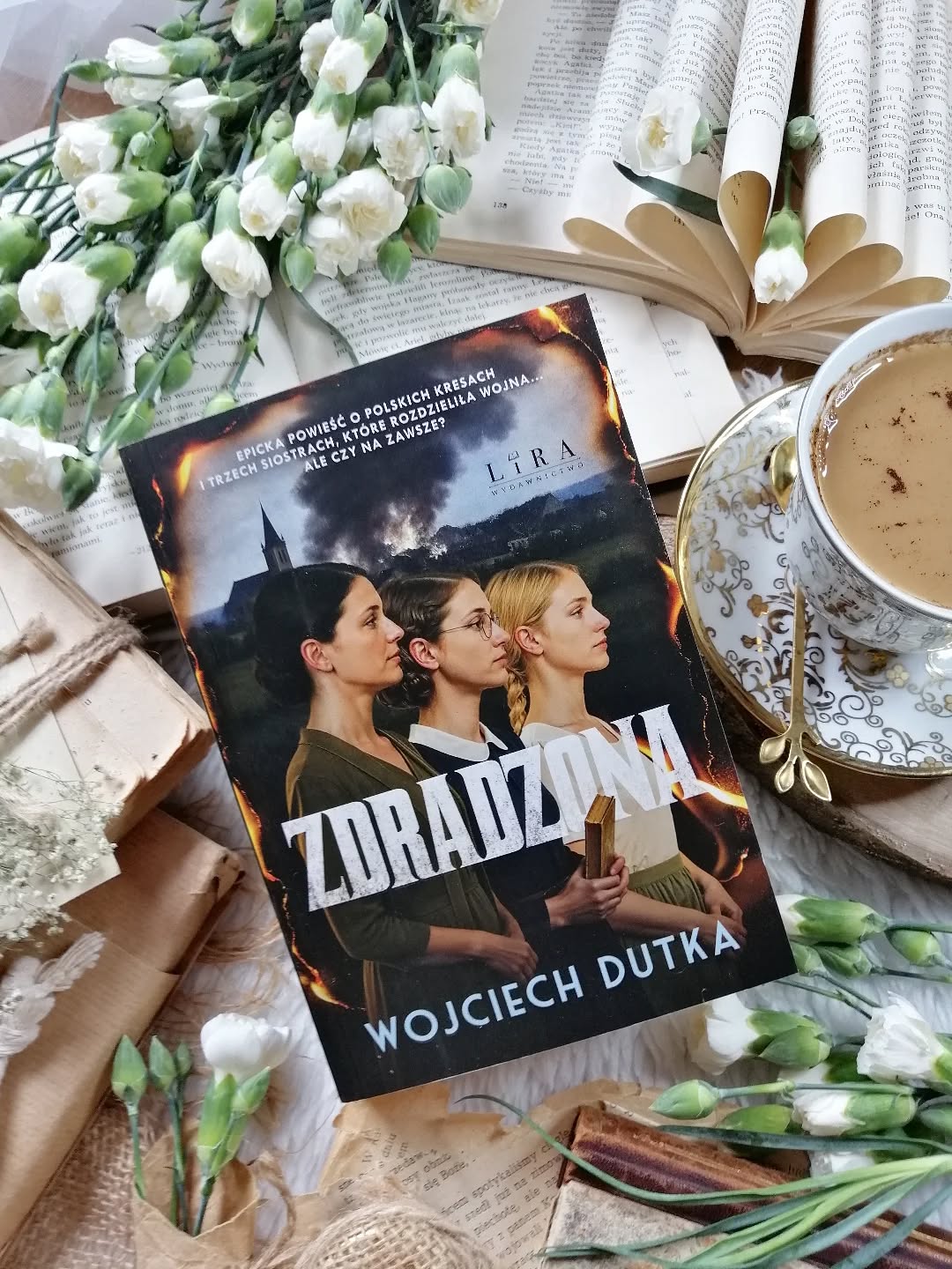 Dzień dobry 🤗  Prawdziwa uczta literacka!  Powieść, której się nie czyta – ją się pochłania! Zachwyca autentyzmem i emocjonalną głębią.  Czy czas rzeczywiście leczy rany, czy tylko uczy nas z nimi żyć?  “Największy ból sprawia czasem odkrycie, że całe dotychczasowe życie, jakie prowadził człowiek, było kłamstwem”.  “Zdradzona” Wojciech Dutka  Jest rok 1930. Kuty – majątek ziemski należący do państwa Szymańskich, położony na Kresach Wschodnich – tętni życiem. Z rodzicami mieszkają w nim trzy siostry. Najstarsza, Konstancja, po poślubieniu oficera Korpusu Ochrony Pogranicza, opuszcza rodzinny dom. Młodsza, Aldona – pełna nieokiełznanej energii, traci grunt pod nogami za sprawą gościa rodziców, młodego kuzyna. Najmłodsza jest wrażliwa i niepokojąco przenikliwa. W tle wyraźnie unosi się zapach grozy – nieuchronnie zbliża się II wojna światowa.  W 1967 roku w Warszawie na komendę Milicji Obywatelskiej trafia włóczęga – mężczyzna milczący, jakby przesiąknięty traumą dawnych wydarzeń. Tymczasem w Nowym Jorku do psychoterapeutki, kobiety po przejściach, przychodzi zakonnica…  Powieść genialna i nieoczywista!  Wielowymiarowa, całkowicie pochłaniająca. Akcja toczy się intrygującym rytmem, przenosząc nas z przedwojennych Kresów do powojennej Warszawy i Nowego Jorku. Perfekcyjnie skonstruowana fabuła splata dramaty, ludzkie słabości i skomplikowane emocje. Autor tworzy świat, który pulsuje realizmem, napięciem i ludzką niedoskonałością.  #wojciechdutka porusza szerokie spektrum trudnych tematów – od losów sióstr Szymańskich, przez ich dramatyczne wybory, po relacje między narodami: Polakami, Ukraińcami, Żydami i Ormianami. W tle wybrzmiewa przepaść klasowa, zderzenie dostatku i biedy, bólu i odwagi, tragedii i przyjaźni. To opowieść o determinacji, wewnętrznej sile, o miłości, o zdradzie, o zemście. O wojnie – tej zewnętrznej i tej toczonej w ludzkim wnętrzu.  Przejmująca, wyjątkowa, wyśmienita historia! Czekam z niecierpliwością na drugi tom! Bardzo polecam! Więcej - recenzja link w bio.  [współpraca barterowa - @wydawnictwolira]  #powieść #literaturapiękna #zdradzona #polecam #czyta #czytajpolsko #czytajksiążki #książka #książki #ksiazkitozycie #polkiczytają