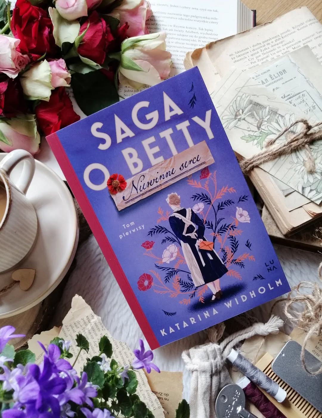 Dzień dobry 🤗  Fascynująca, subtelna historia.  Jak ja lubię takie opowieści… pełne emocji, życiowych wyborów i kobiet, które mimo przeciwności próbują odnaleźć własne miejsce w świecie.  “Niewinne serca” – Katarina Widholm  Pierwszy tom cyklu #sagaobetty przenosi nas do Sztokholmu lat trzydziestych. To właśnie tam poznajemy Betty – ambitną, wrażliwą dziewczynę, która od zawsze kocha książki i marzy o poznawaniu świata. Niestety realia tamtych czasów sprawiają, że dalsza nauka pozostaje jedynie marzeniem.  W 1937 roku Betty wyjeżdża do Sztokholmu i podejmuje pracę jako służąca w domu zamożnego doktora. Jej codzienność wypełniona jest ciężką pracą i uszczypliwymi uwagami pani domu. Wsparciem staje się dla niej druga pomoc domowa, Viola. Z kolei znajomość z przystojnym wykładowcą Martinem Fischerem otwiera przed Betty zupełnie nowy świat – rozmów, wiedzy, marzeń i rodzących się uczuć...  Autorka niezwykle wiarygodnie oddaje realia życia służby w Sztokholmie lat 30. – ciężką pracę, nierówne traktowanie czy trudne relacje z pracodawcami. W tle coraz wyraźniej pobrzmiewają niepokojące echa nadchodzącej wojny, widmo nazizmu i prześladowania Żydów.  Styl autorki jest płynny, bardzo przyjemny w odbiorze. Pisze z empatią i ogromną wrażliwością, a bohaterowie są autentyczni i skomplikowani – budzą wiele emocji. Miałam wrażenie, jakbym razem z nimi przemierzała ich kręte życiowe ścieżki.
Betty skradła moje serce od pierwszych stron. Jest silna, odważna i mądra, a jednocześnie krucha. Na naszych oczach powoli dorasta, uczy się życia i oddaje serce mężczyźnie, który – przynajmniej w oczach innych – wydaje się zupełnie nieodpowiedni. Ta decyzja przynosi konsekwencje, z którymi musi się zmierzyć.  To historia, która pozwala wejść w życie bohaterów i przeżywać razem z nimi radości, rozczarowania i trudne chwile.  Była to piękna, poruszająca, momentami bolesna literacka podróż. Z niecierpliwością czekam na kolejne tomy.  Bardzo polecam, więcej link w bio.  Współpraca barterowa - @wydawnictwoluna  #niewinneserce #powieść #książka #bokstagram