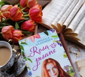 „Rosą pisane” Urszula Gajdowska - powieść obyczajowa o małych światłach nadziei, o odwadze stawiania granic i o sile, jaką daje wsparcie innych. O tym, że miłość nie powinna ranić, a życie można zacząć od nowa.